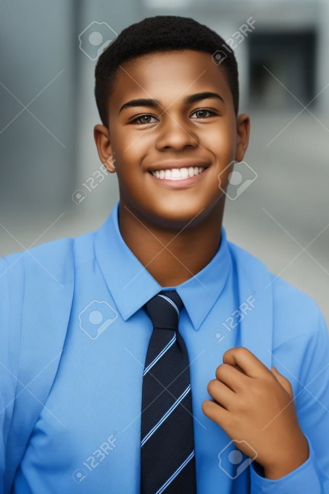 制服の外の建物の男子十代の学生の肖像