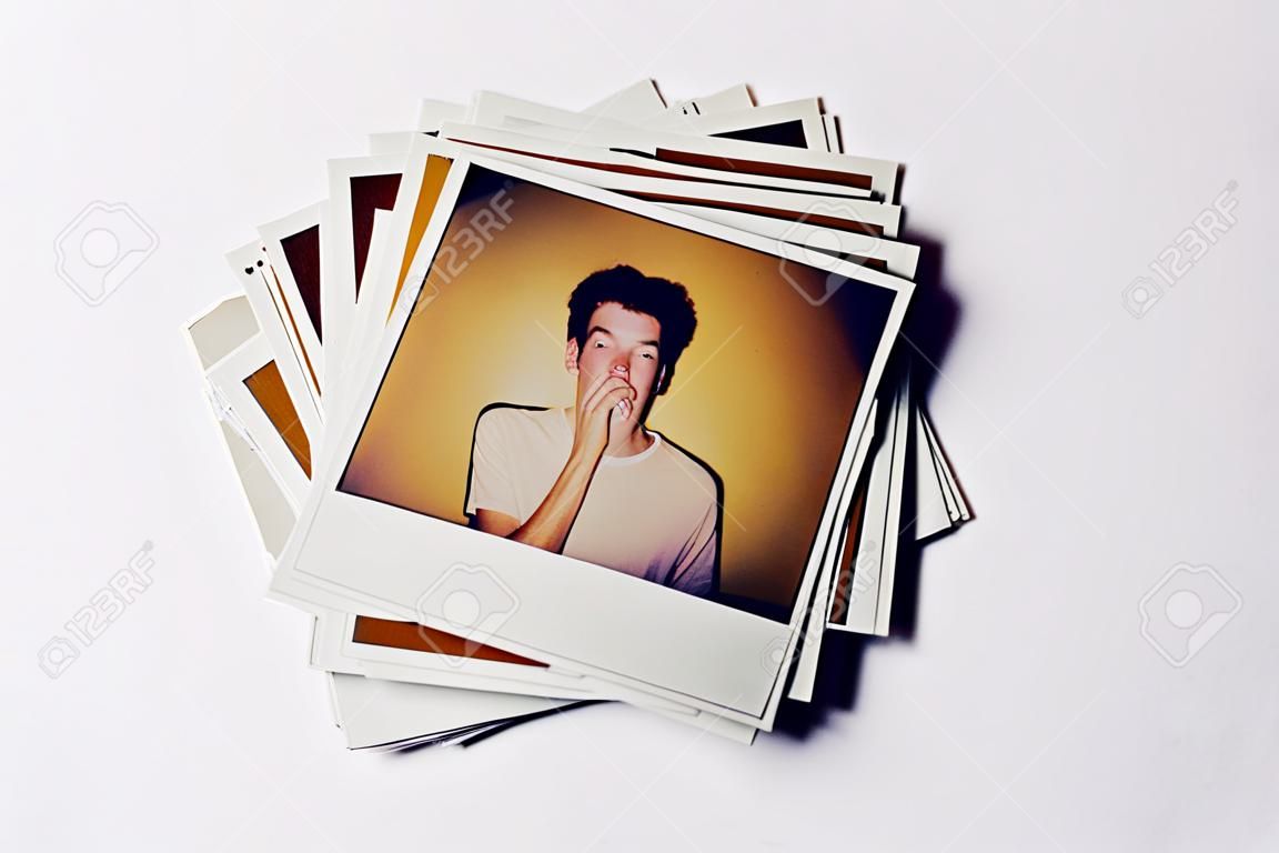 Stack Of Instant Film Photos From Modeling Casting In Studio With Shot Of Young Man On Top