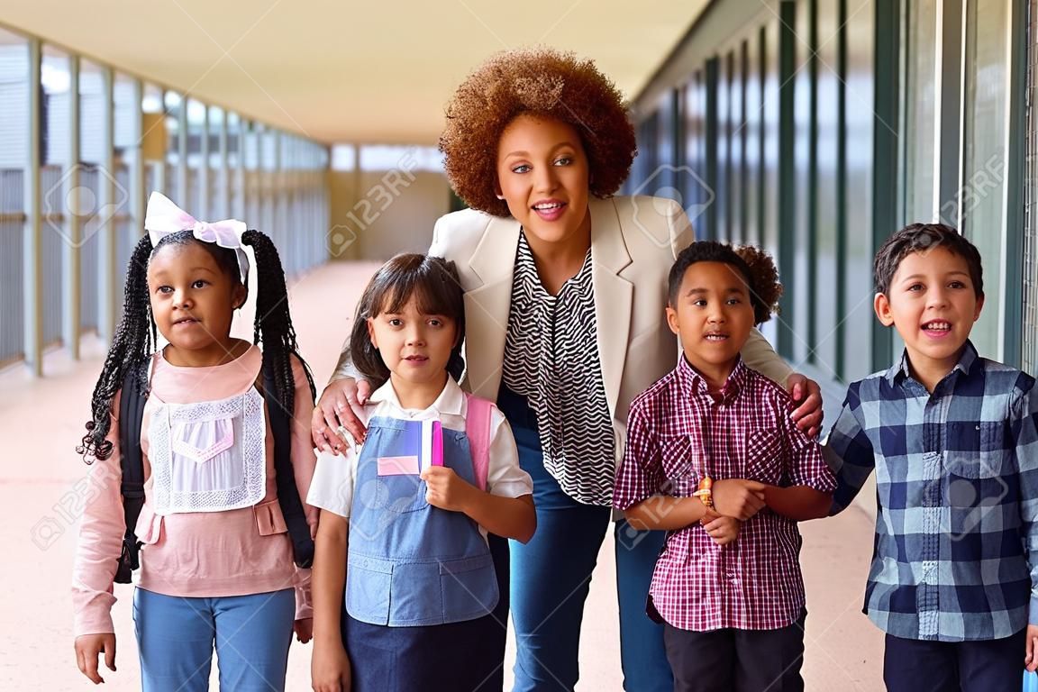 Portrait d'élèves du primaire multiculturels avec une enseignante à l'extérieur à l'école