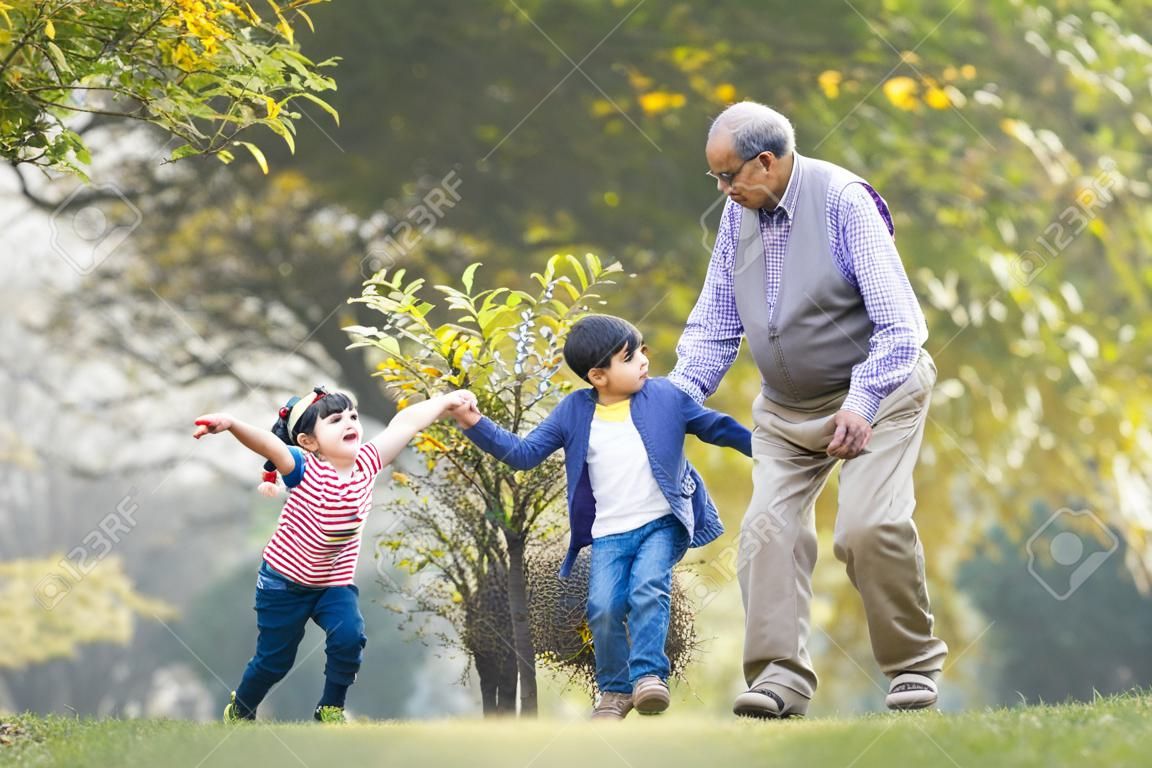 Grandfather playing with grandchildren at park