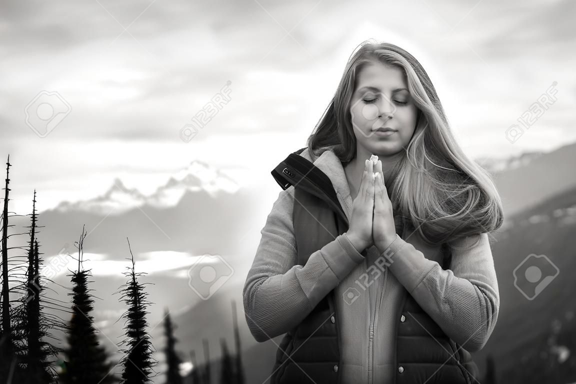 photo noir et blanc d'une belle fille méditant dans les montagnes