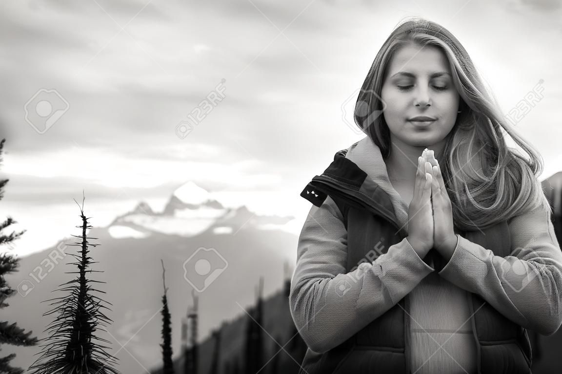 photo noir et blanc d'une belle fille méditant dans les montagnes