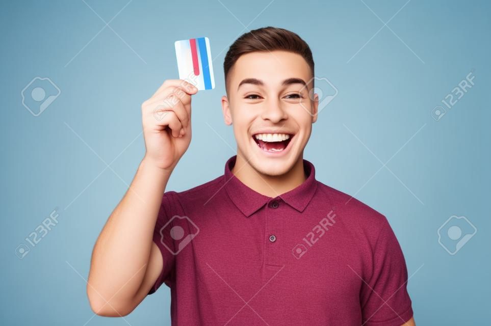 Gelukkige jongeman toont zijn creditcard