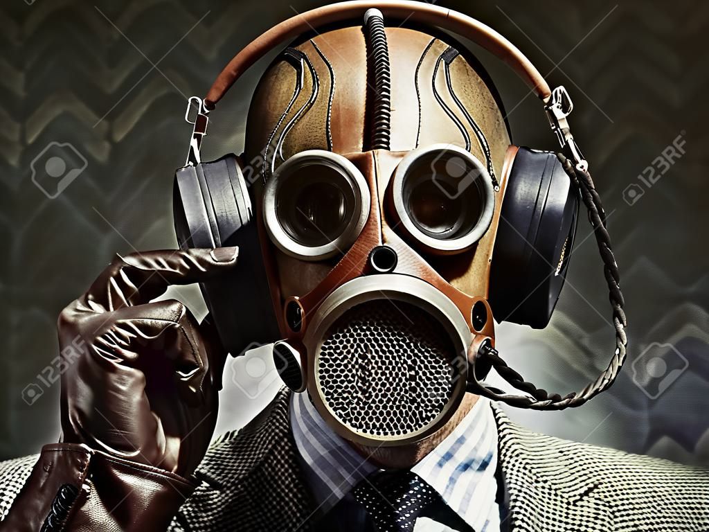 Mężczyzna ma na sobie maski gazowej i rocznika słuchawek do słuchania muzyki.