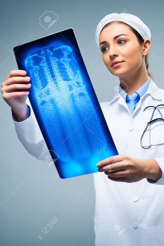 Уверен женщина-рентгенолог проверки рентгеновского изображения позвоночника.