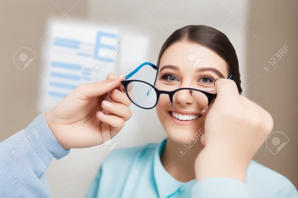 Young happy woman trying her new pair of glasses after the eye exam