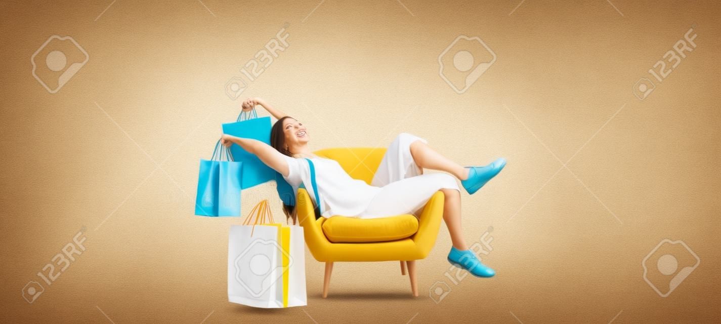 Alegre feliz mujer adicta a las compras con muchas bolsas de compras, está sentada en un sillón y celebrando, espacio en blanco