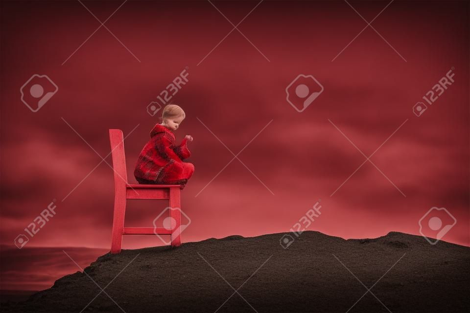 Girl on a red wooden chair on a empty stony landscape in Iceland. Toned.