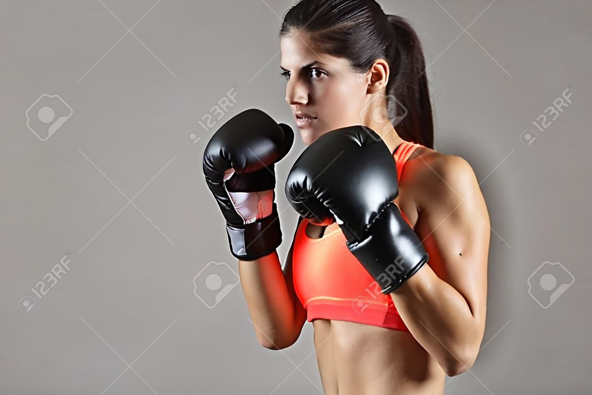 schönen Fitness-Frau mit den schwarzen Boxhandschuhen