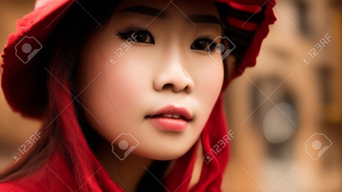 Retrato de uma bela jovem asiática com chapéu na cidade