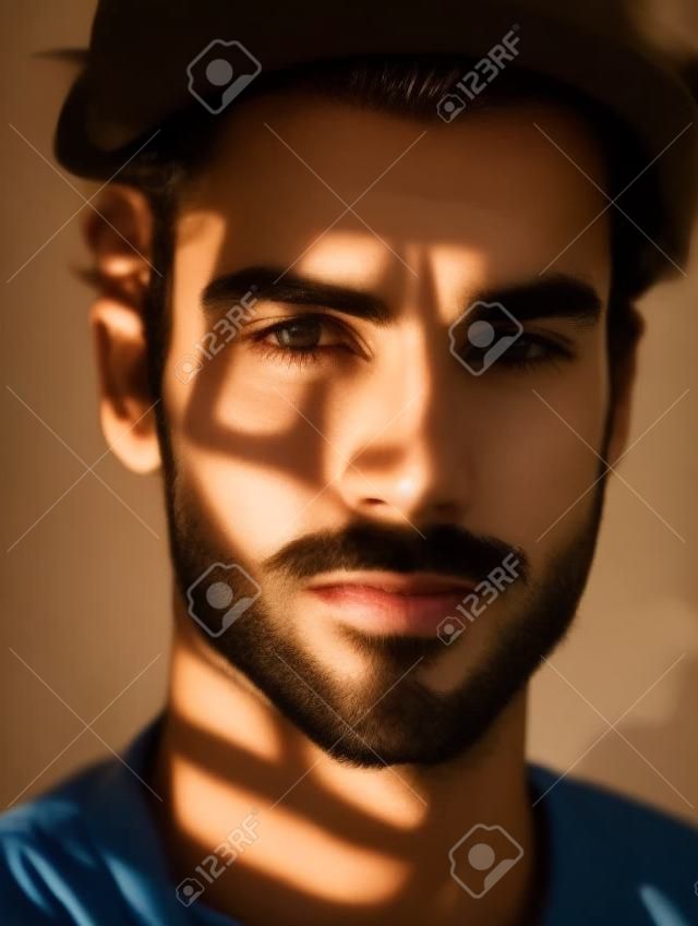 Retrato de um jovem bonito com sombras no rosto.