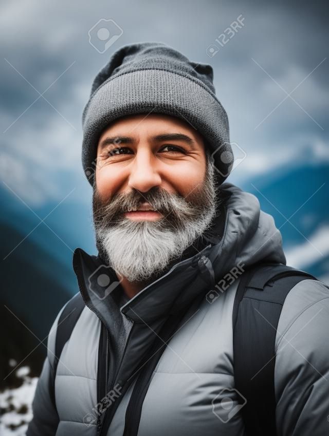 Portrait of a bearded man with a gray beard in the mountains.