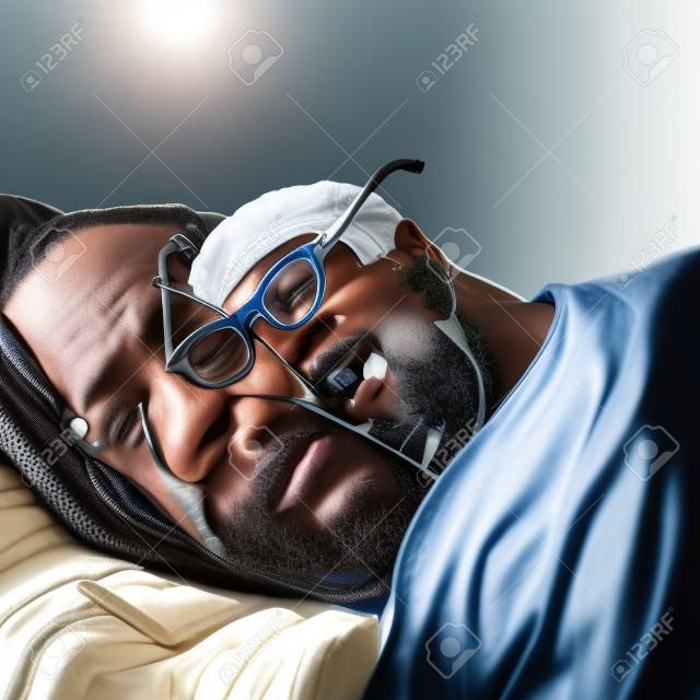 흑인 남자가 안경을 쓰고 자고 있고 그 옆에는 전화기가 놓여 있습니다. 사업가 일상