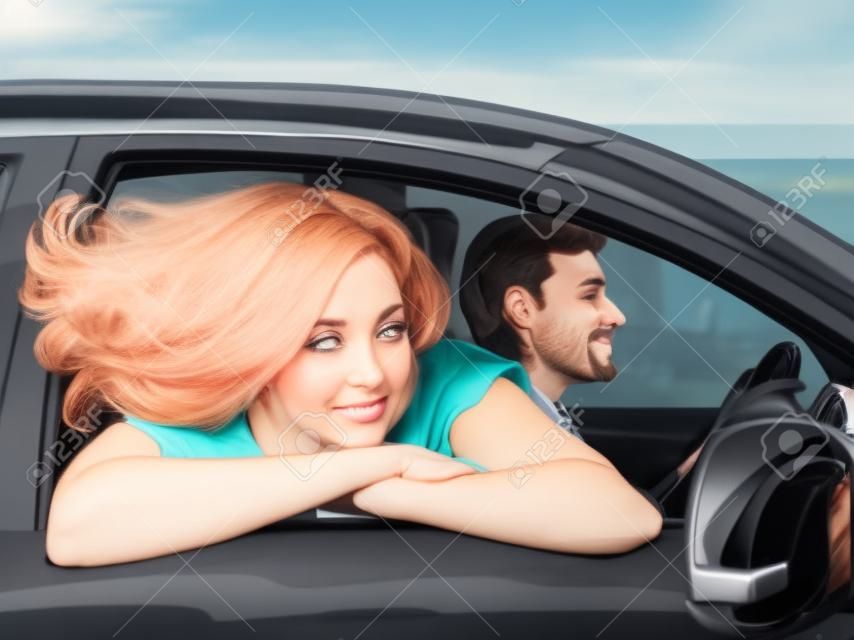 een vrouw kijkt uit een auto raam, haar haar fladderend in de wind. man rijden