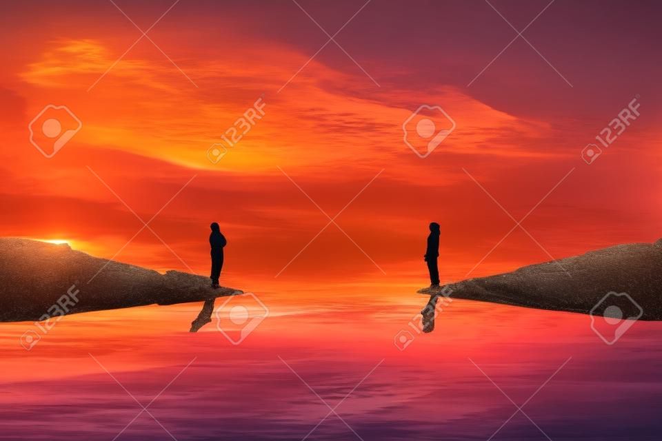 Ein Junge und ein Mädchen stehen auf verschiedenen Seiten eines Flusses und überlegen, wie sie sich über einen wunderschönen Sonnenuntergangshintergrund erreichen können. Eine imaginäre Brücke bauen. Lebensreise- und Suchkonzept.