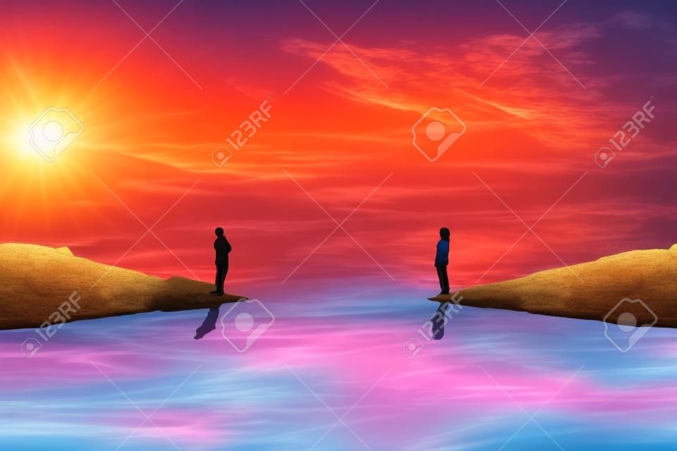 一个男孩和一个女孩站在河的两边，思考如何在美丽的日落背景下互相达到。建立一个假想的桥梁。人生旅途和搜索的概念。