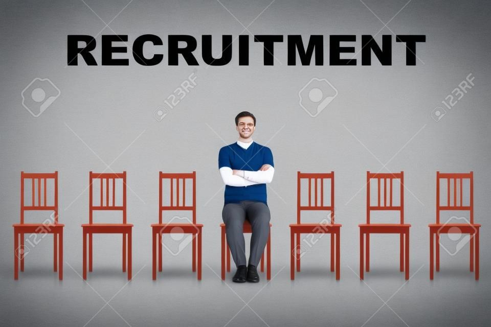 Young man sitting on a chair as perfect candidate for a vacant job place waiting to be hired. Business career development concept, job recruitment and employment. Human resources management choice.