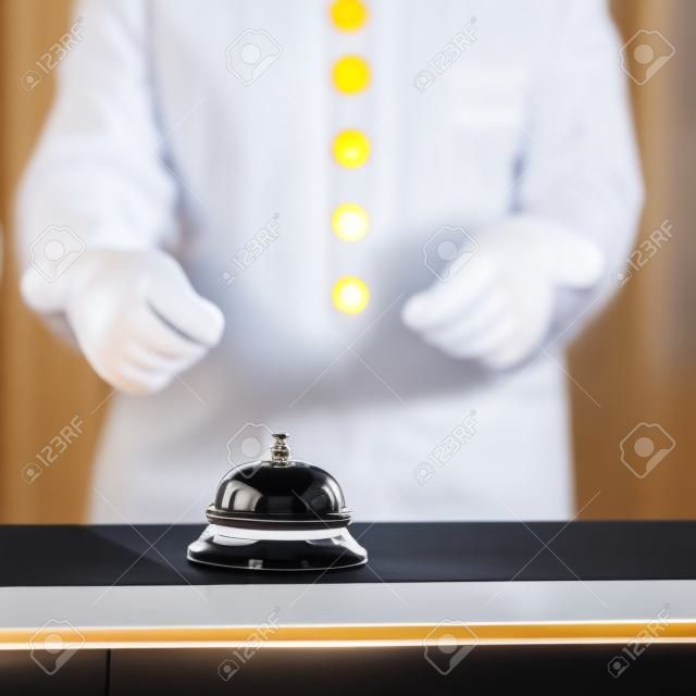 Concierge, fehér kesztyűt mutatott hotel csengőt counter