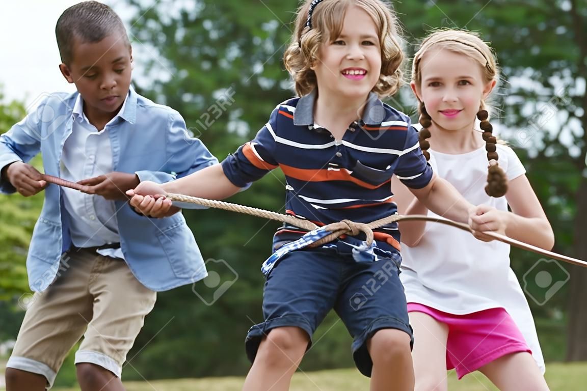 Groep kinderen die aan een touw trekken in het park