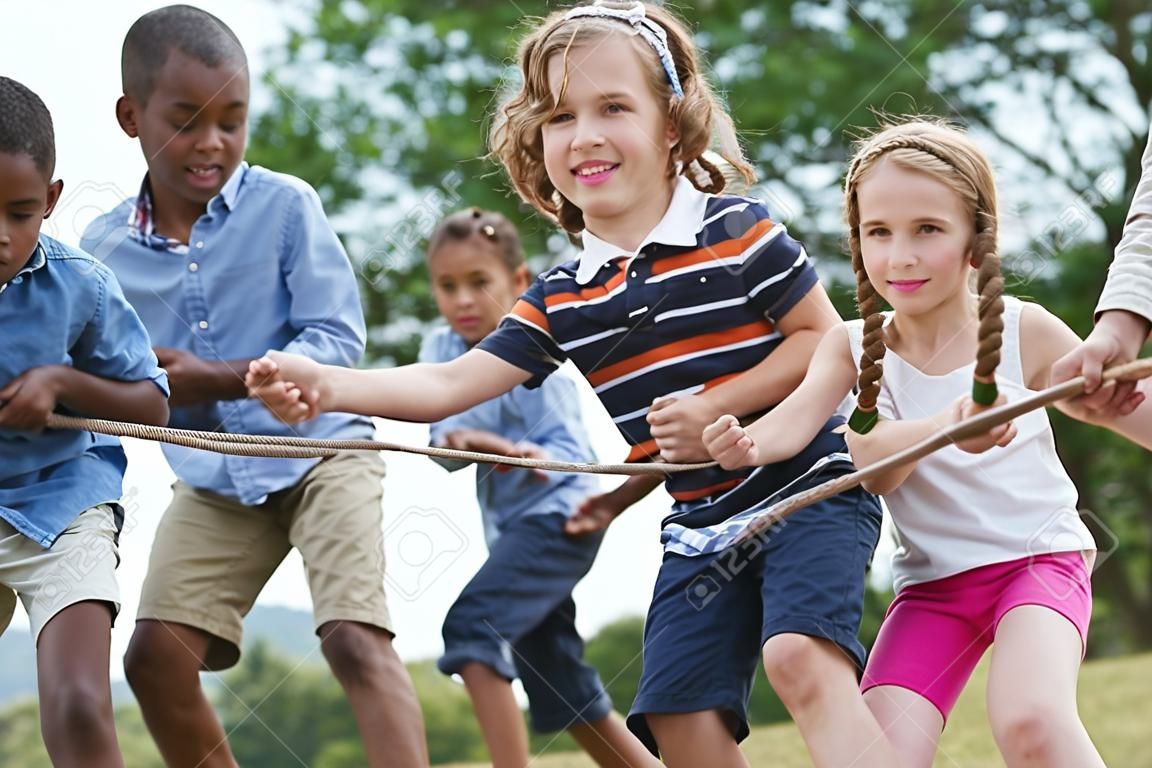 Groep kinderen die aan een touw trekken in het park