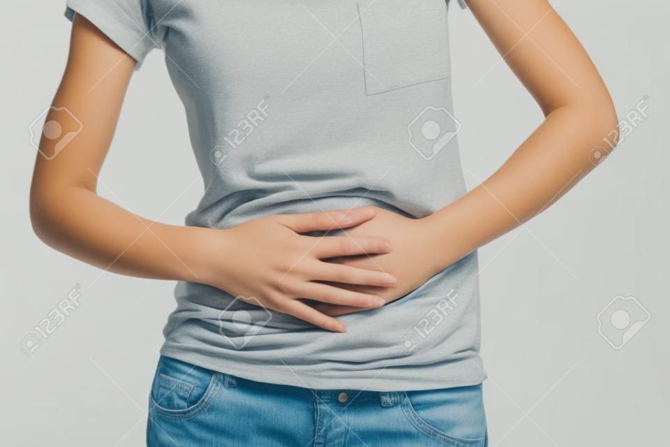 Young woman with bellyache holding hands on her stomach