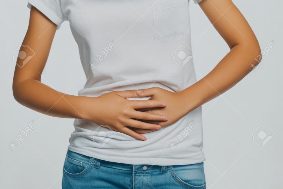 Giovane donna con mal di pancia tenendo le mani sul suo stomaco