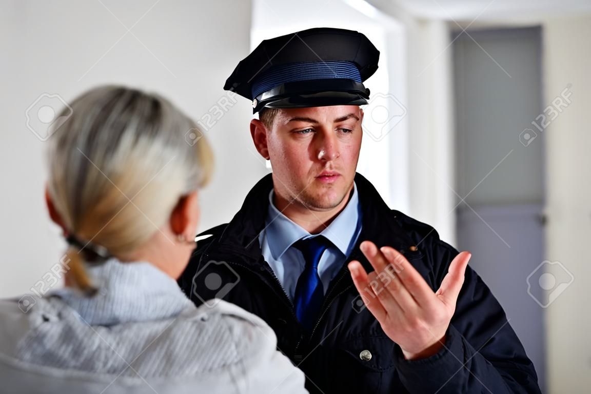 Policjant przeprowadza przesłuchanie świadka po włamaniu i rozmawia ze świadkami