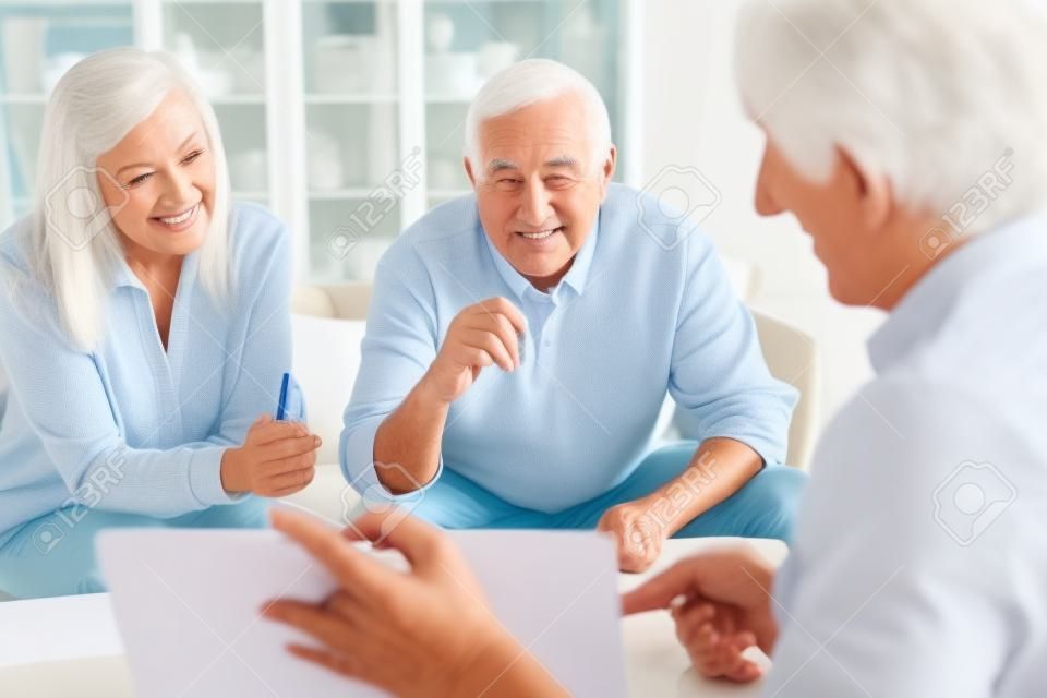 Starsza para uzyskująca porady dotyczące finansowania opieki i emerytury od doradcy finansowego
