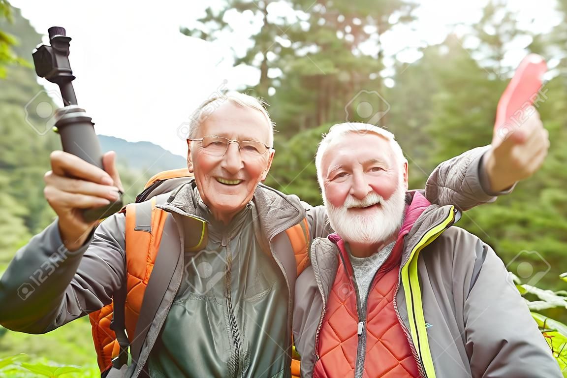 Portrait of happy elderly male friends gesturing while hiking in forest during vacation