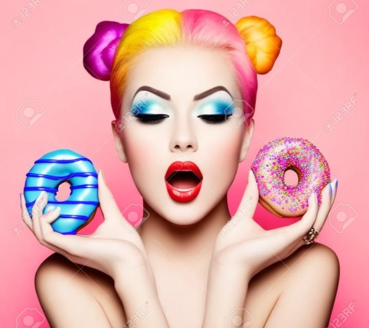 美女模特的女孩採取豐富多彩的甜甜圈。節食的概念