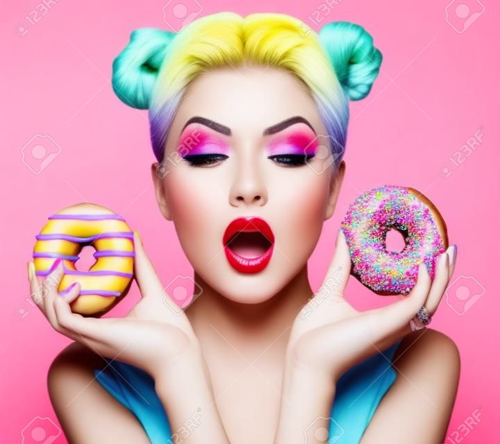 美女模特的女孩採取豐富多彩的甜甜圈。節食的概念