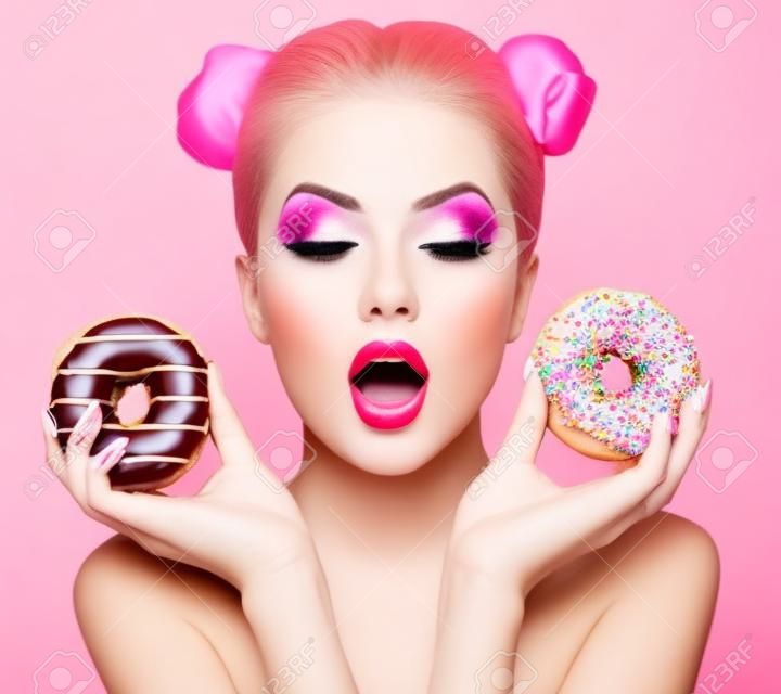 Beauty fashion model girl taking sweets and colorful donuts