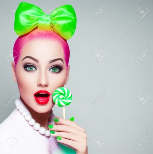 Modelo de moda belleza niña comiendo piruletas de colores