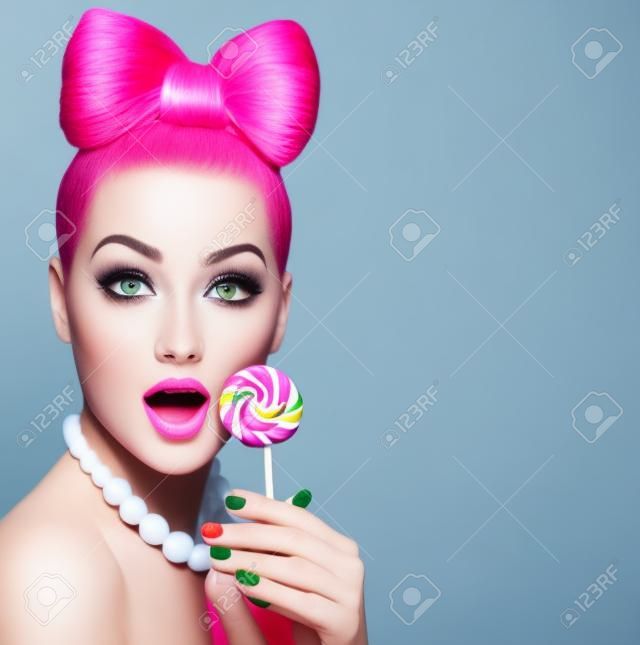 Modelo de moda belleza niña comiendo piruletas de colores