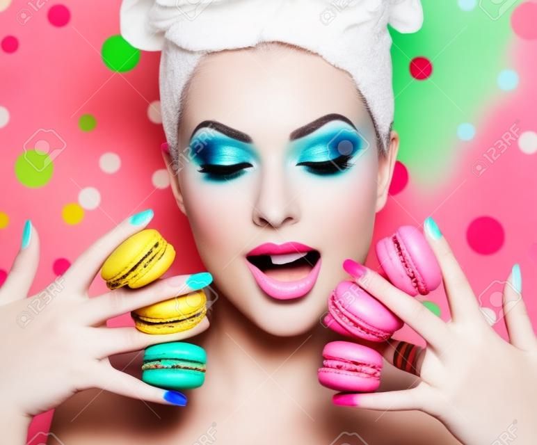 Mooie mode model meisje met kleurrijke make-up nemen kleurrijke macaroons