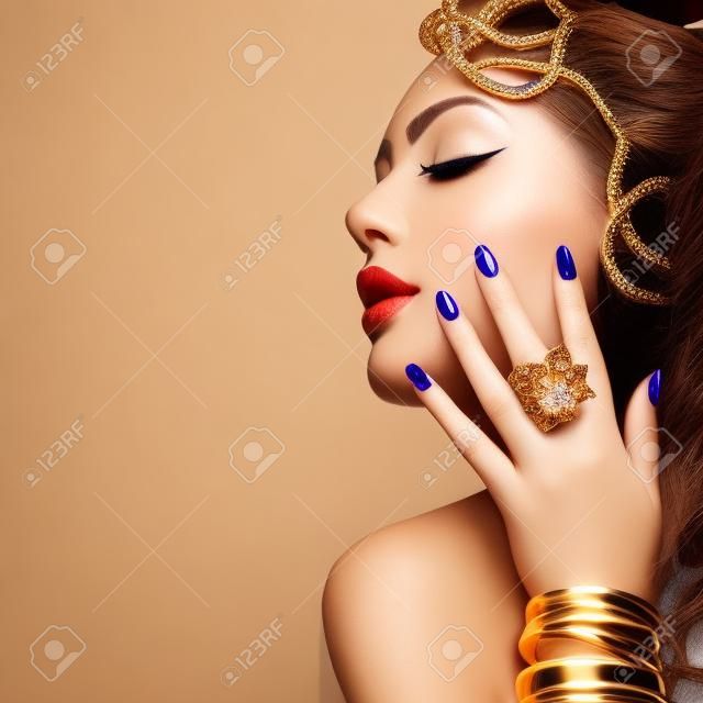 Beauty Mode Frau mit goldenen Make-up, Accessoires und Nägel