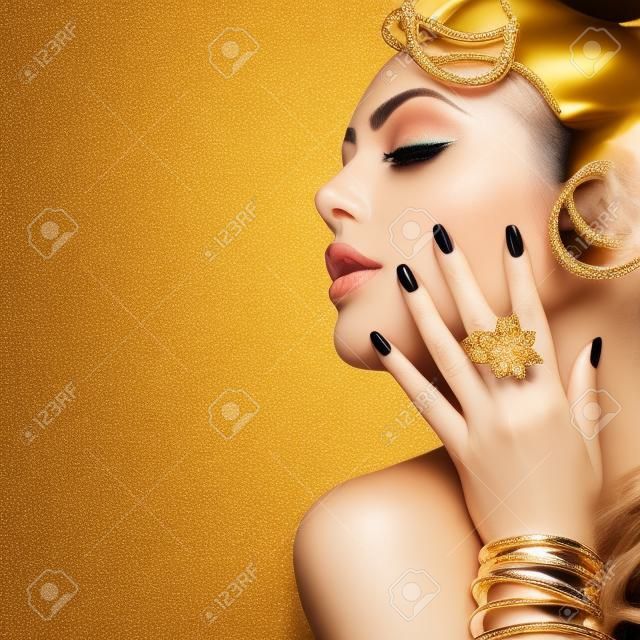 Beauty Mode Frau mit goldenen Make-up, Accessoires und Nägel