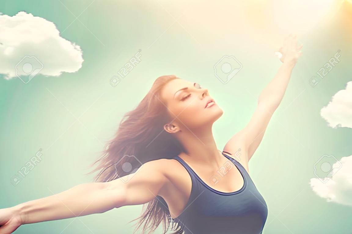 自由快乐的女人在天空和太阳