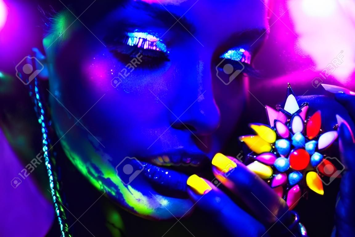 Mode femme à la lumière au néon, portrait d'un modèle de beauté avec le maquillage fluorescent