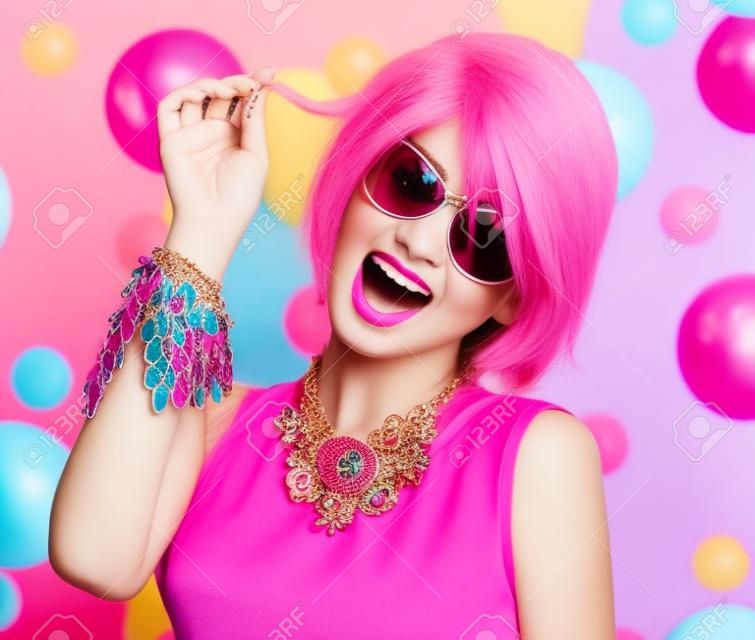 Modello di bellezza adolescente con i capelli rosa, accessori colorati di moda e occhiali da sole