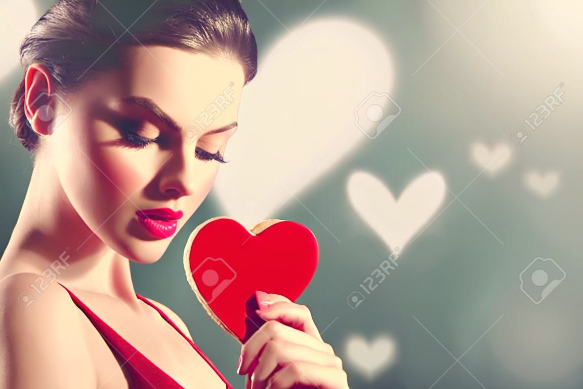 День Святого Валентина. Красота молодая модель девушка с Валентина в форме сердца печенье