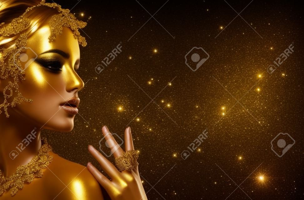 Золотая женщина кожи. Красота моды модель девушка с золотой макияж, волосы и ювелирные изделия на черном фоне