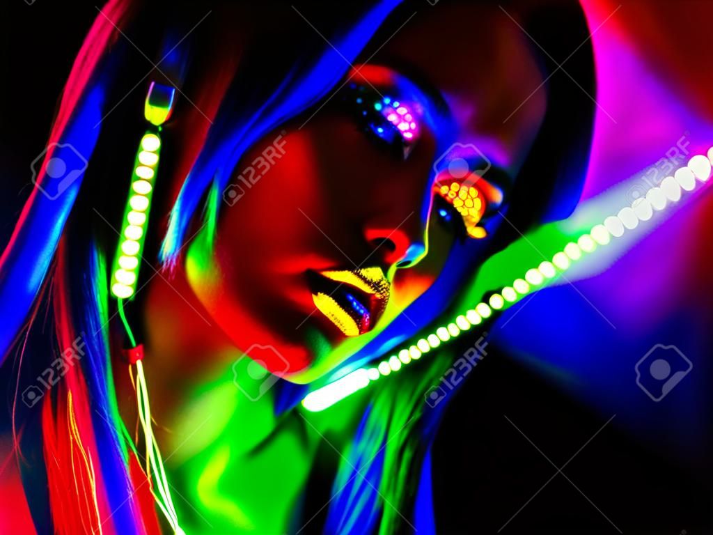 Fashion model woman in neon light. Portrait of beautiful model girl with colorful fluorescent makeup