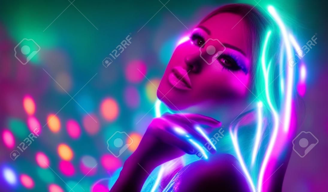 Fashion disco woman. Dancing model in neon light, portrait of beauty girl with fluorescent makeup. Art design