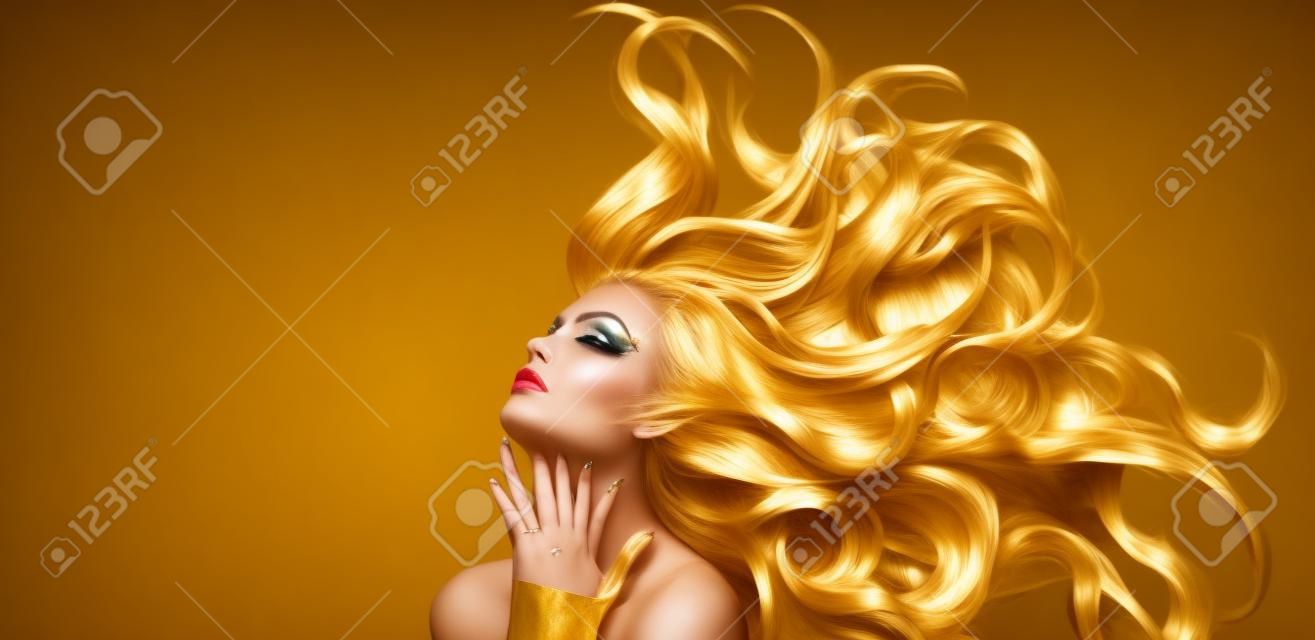 Złota Kobieta. Piękna dziewczyna moda model ze złotym makijażem, długie włosy na czarno