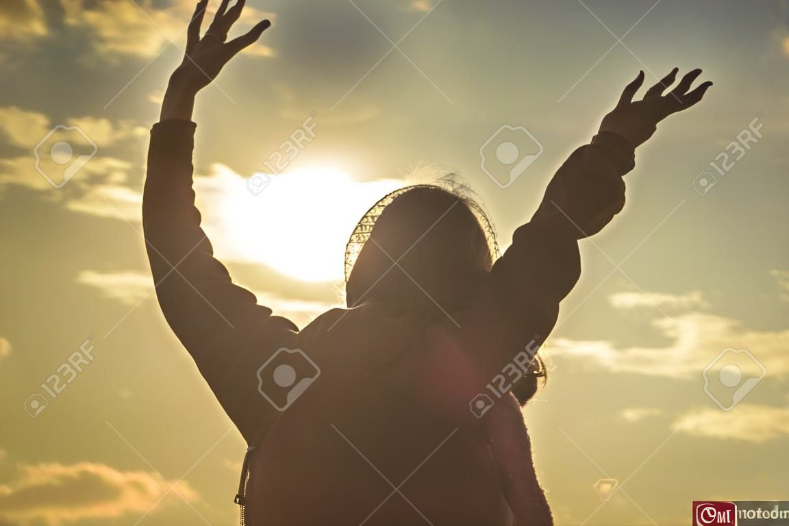 일출 정상에서 축하하는 여자. 일몰에 손을 뻗고 있는 실루엣 성인 여성. 손을 드는 어린 소녀는 자연을 즐기는 야외에서 자유와 휴식을 느낍니다. 성공 개념