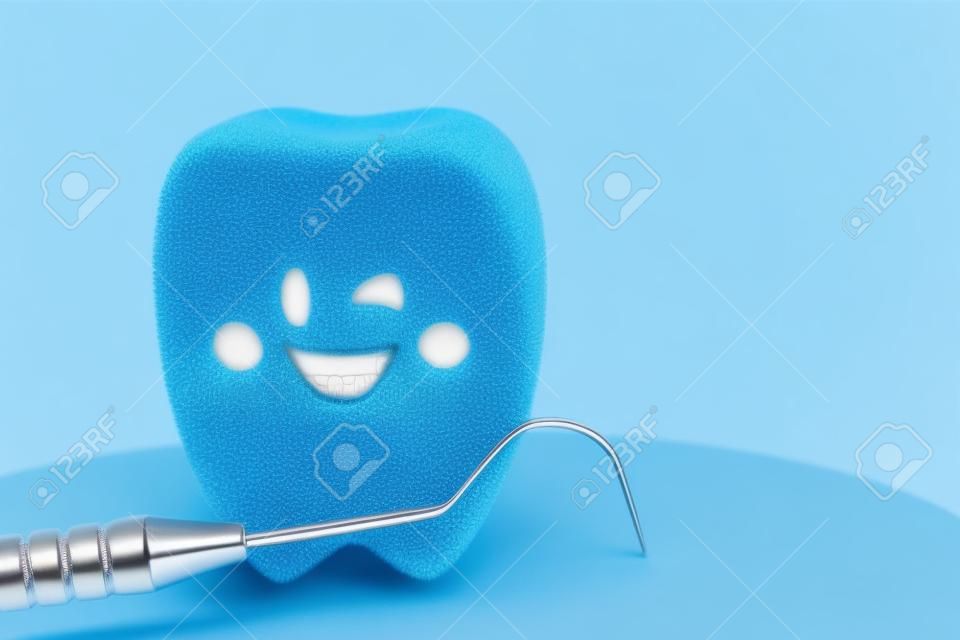 Zbliżenie narzędzi dentystycznych i modelu zębów uśmiechu na niebieskim tle