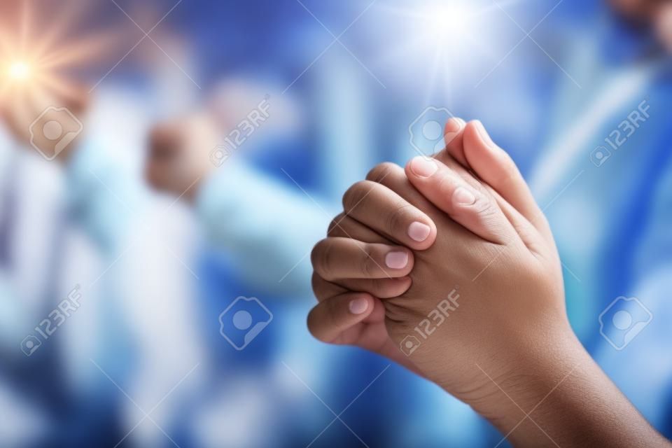 그룹 사람들은 하나님의 축복을 위해 기도하기 위해 손을 잡고 있습니다.
