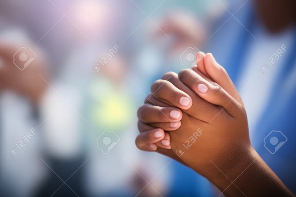 그룹 사람들은 하나님의 축복을 위해 기도하기 위해 손을 잡고 있습니다.