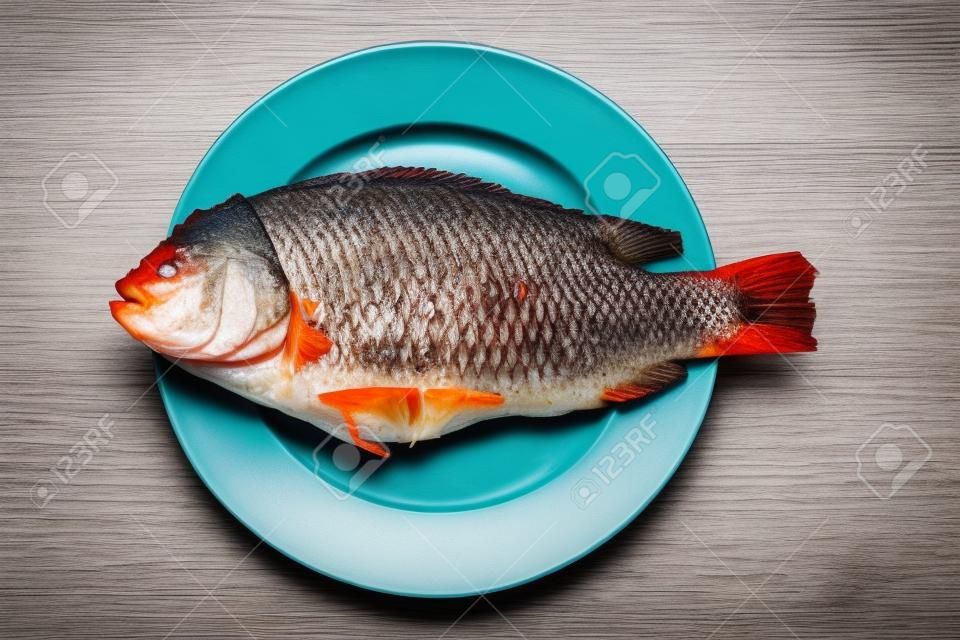 Rode tilapia brengen zout gegrilde vis op witte schaal
